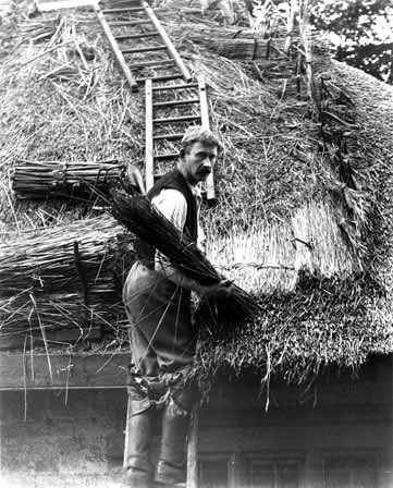 A man thatching, early twentieth century. The tools, material and processes of thatching have changed very little for hundreds of years.