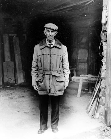 Mr Ron How of Brompton Regis Carriage Works in the doorway of the wheelwrights shop, 1986.