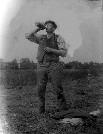 A peat worker taking a break during work, c.1930s. The drink could be cider or cold tea.